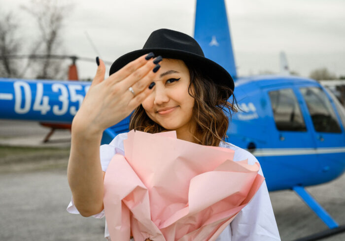 Девушка на фоне вертолета после полета от компании "Captour"
