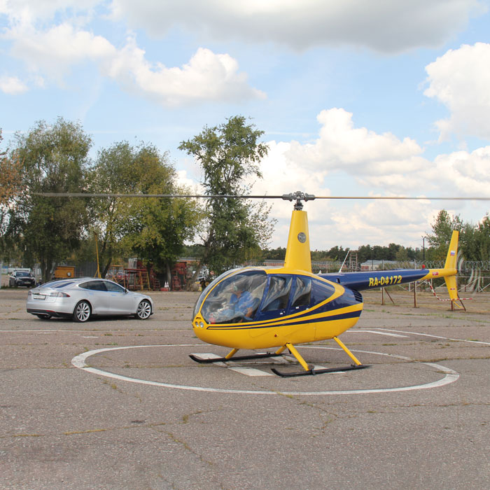 Вертолет и машина Tesla на вертолетной площадке в Мячково