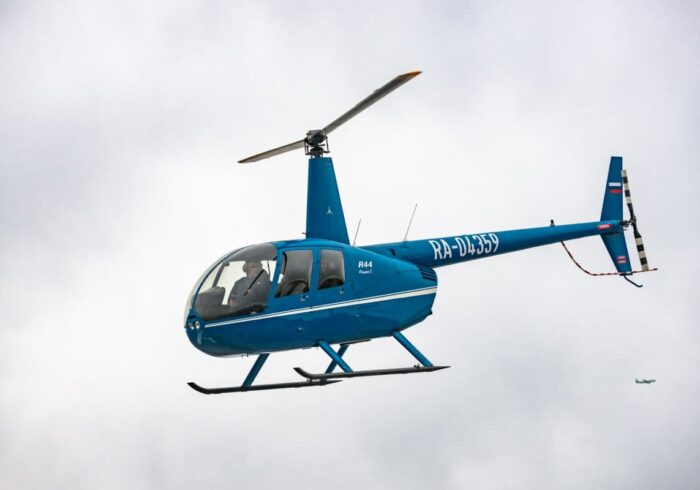 Синий вертолёт Robinson R44 в небе от компании "Captour"