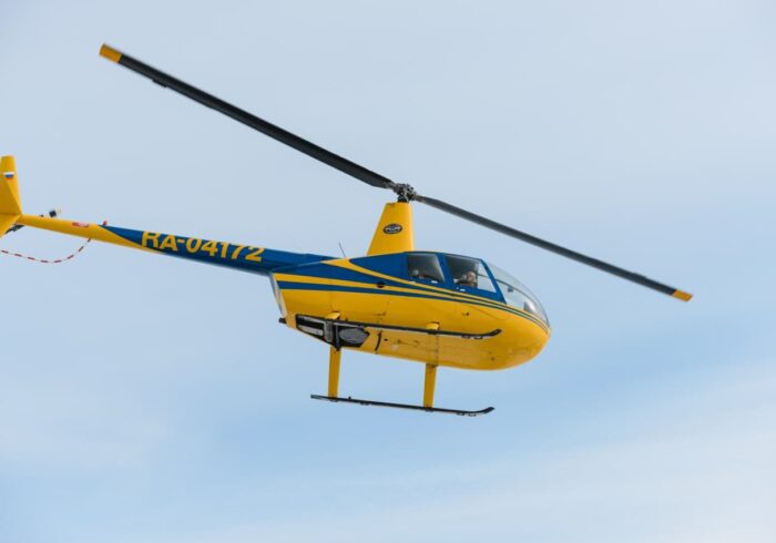 Вертолёт Robinson R44 в небе в полете от компании "Captour"