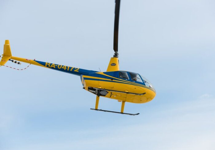 Желтый Robinson R44 в полете от компании "Captour"